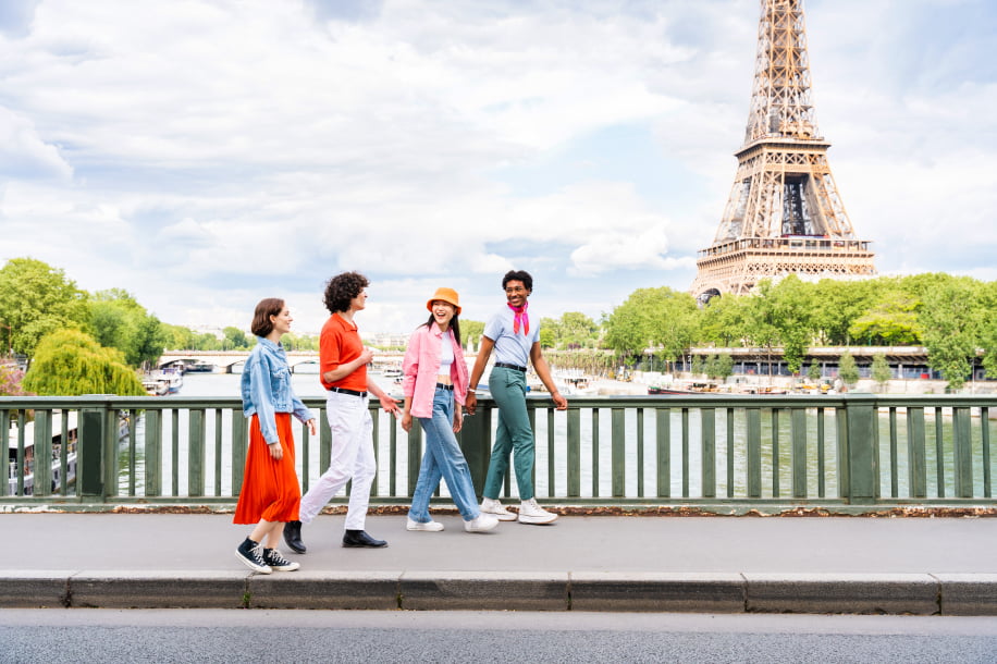 full length young woman standing against eiffel tower
